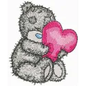 Teddy bear holding a heart-shaped pillow embroidery design, ideal for embellishing baby onesies and blankets.