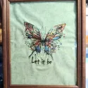 Closeup of Butterfly Let It Be embroidery design featuring intricate stitching patterns for embellishing fabrics.