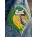 Tree leaf with a birdie embroidery design, showcasing intricate stitching for a nature-inspired project.