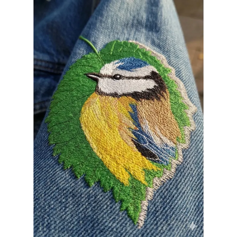 Tree leaf with a birdie embroidery design, showcasing intricate stitching for a nature-inspired project.