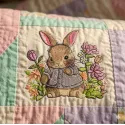 Embroidery design featuring a baby bunny surrounded by vibrant forest flowers, perfect for children's apparel.