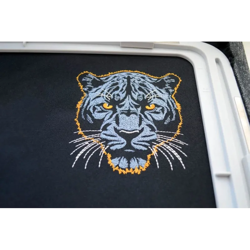 Closeup of dark blue panther embroidery design on a dark background, showcasing intricate stitching details.