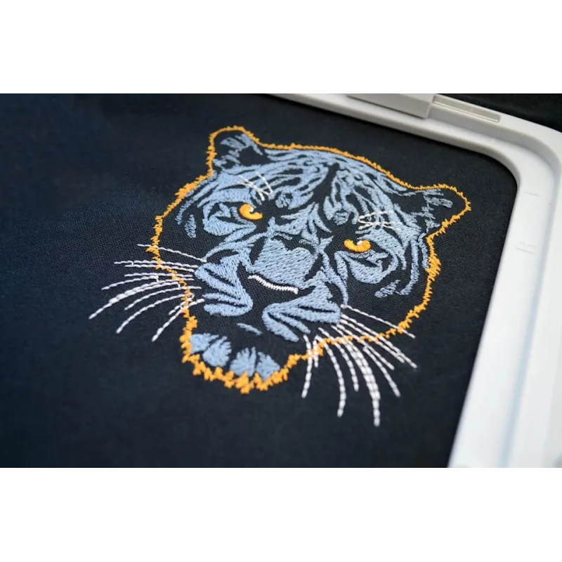 Embroidery design of a dark blue panther on a dark background, showcasing intricate stitching details.