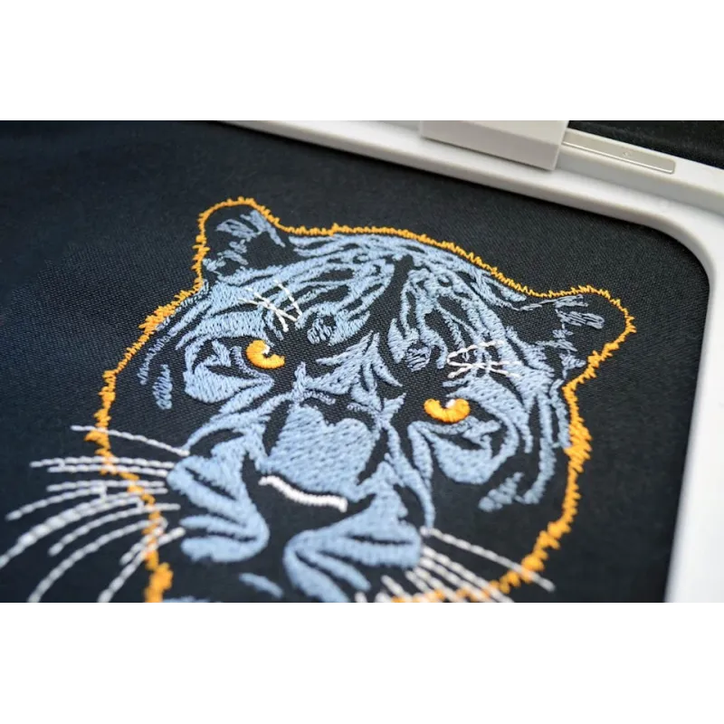 Dark blue panther embroidery design on a dark background, showcasing intricate details for stitching.