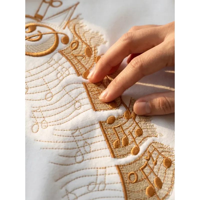 Music giraffe embroidery design mockup showing stitched pattern details